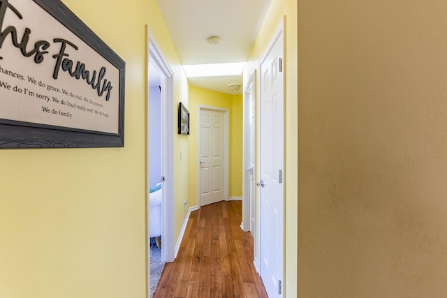 hallway with baseboards and wood finished floors