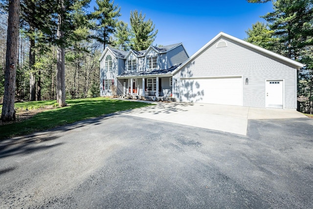 view of front of house with aphalt driveway, a front lawn, covered porch, and a garage