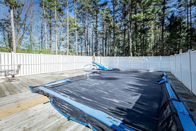 view of pool featuring a wooden deck and a fenced backyard