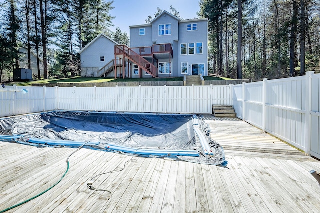 view of swimming pool featuring stairway, a fenced backyard, a fenced in pool, and a deck
