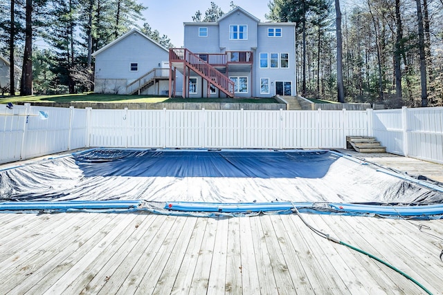 view of pool featuring a gate, a fenced backyard, stairway, and a deck
