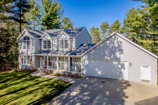 traditional-style home with an attached garage, driveway, a porch, and a front yard