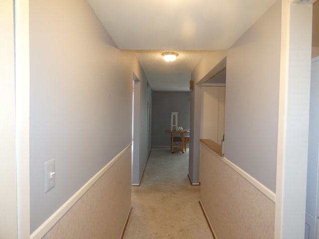 hall with light carpet and an upstairs landing