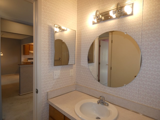 bathroom with wallpapered walls and vanity