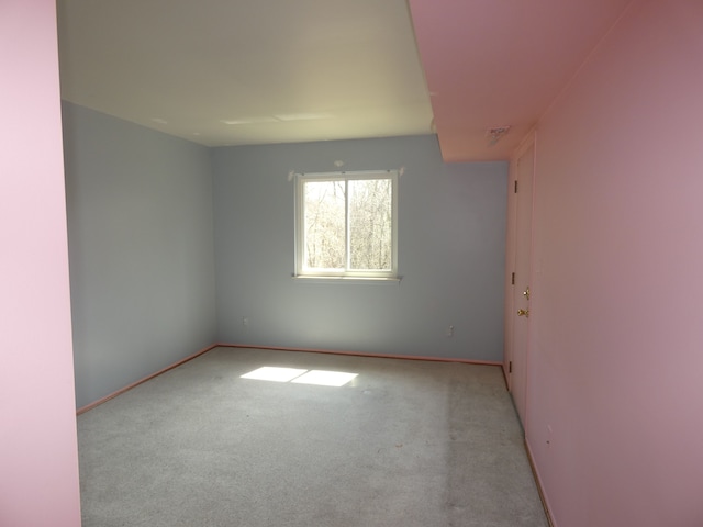 carpeted spare room featuring baseboards
