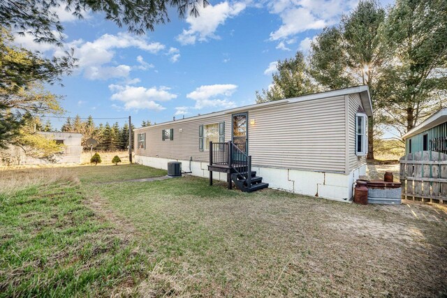 10269 30th Ave, Evart, MI 49631 - rear view of house with central AC unit and a yard
