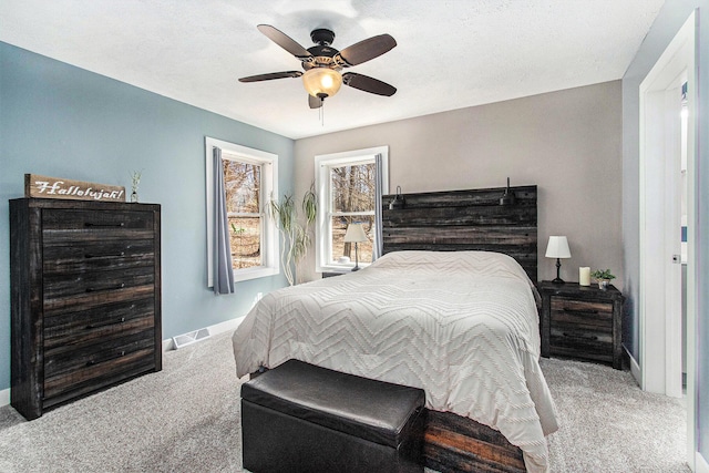 carpeted bedroom with ceiling fan, baseboards, and visible vents