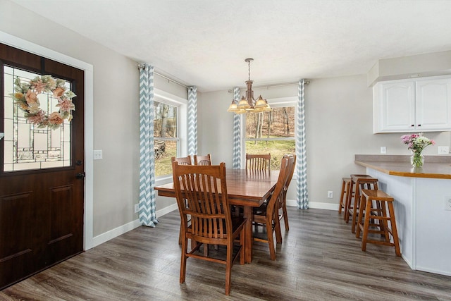 dining space featuring an inviting chandelier, dark wood-style floors, and baseboards