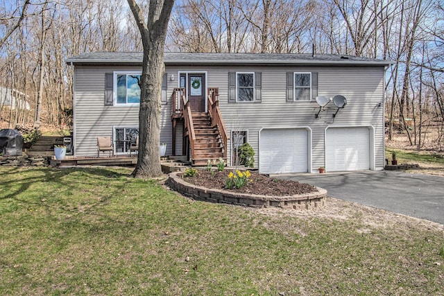 view of front of home featuring a front lawn, aphalt driveway, and a garage