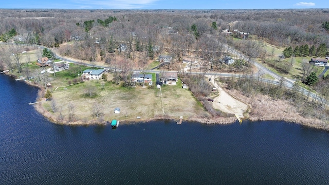 birds eye view of property featuring a forest view and a water view