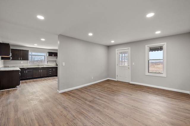 entrance foyer with recessed lighting, light wood-style flooring, a healthy amount of sunlight, and baseboards