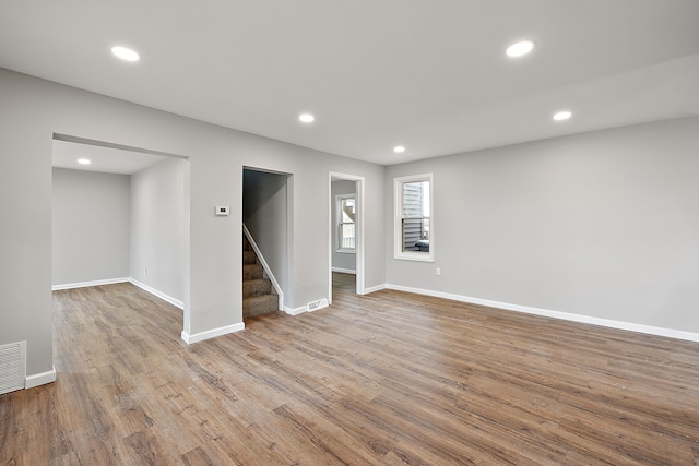 basement featuring stairway, wood finished floors, baseboards, visible vents, and recessed lighting