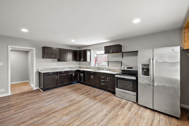 kitchen featuring light wood finished floors, light countertops, a sink, and appliances with stainless steel finishes