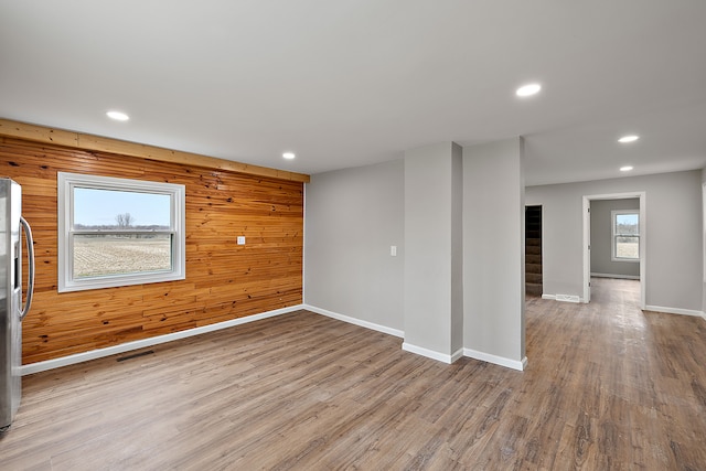 empty room featuring wood finished floors, stairs, baseboards, visible vents, and recessed lighting