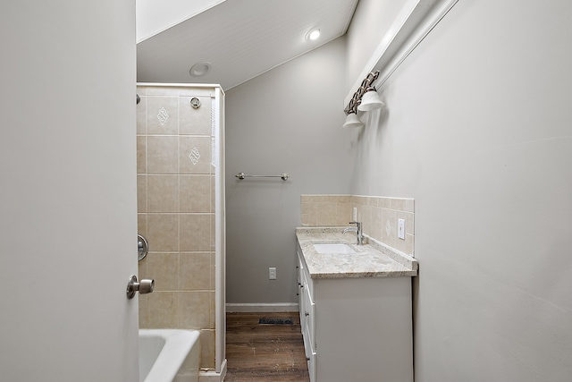 bathroom with baseboards, backsplash, wood finished floors, vanity, and tub / shower combination