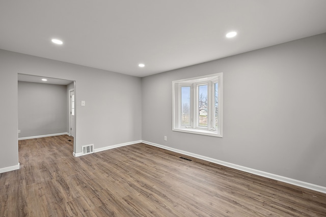 below grade area featuring baseboards, wood finished floors, visible vents, and recessed lighting