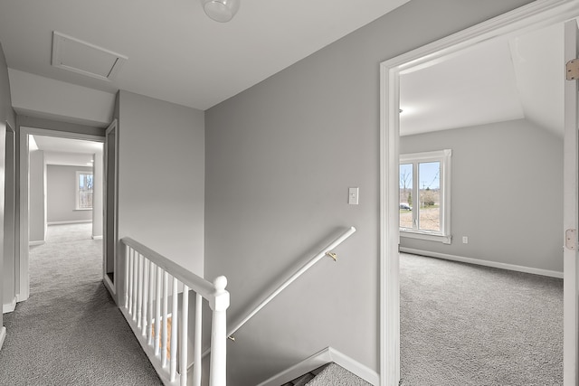 hallway featuring carpet floors, a wealth of natural light, baseboards, and an upstairs landing