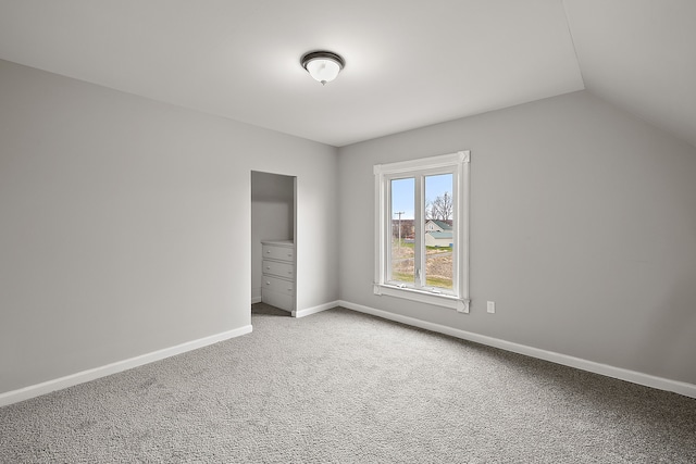 unfurnished bedroom with baseboards, lofted ceiling, and carpet flooring