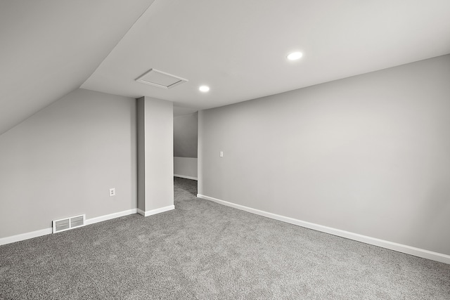 additional living space featuring attic access, lofted ceiling, carpet flooring, visible vents, and recessed lighting