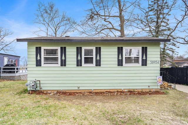 view of front of house with fence and a front lawn