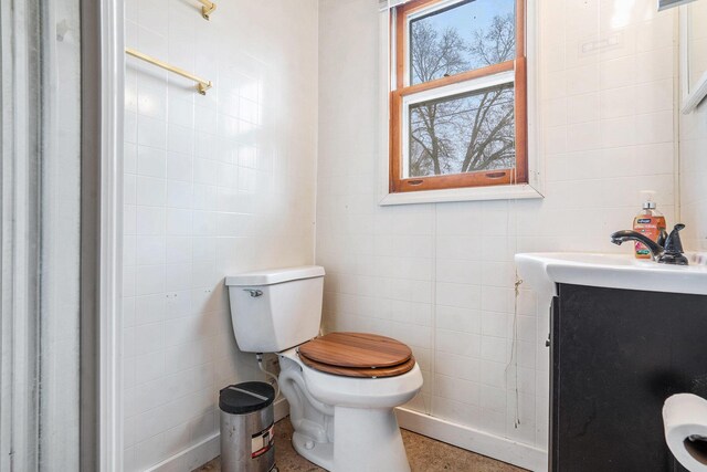 bathroom featuring tile walls, vanity, and toilet