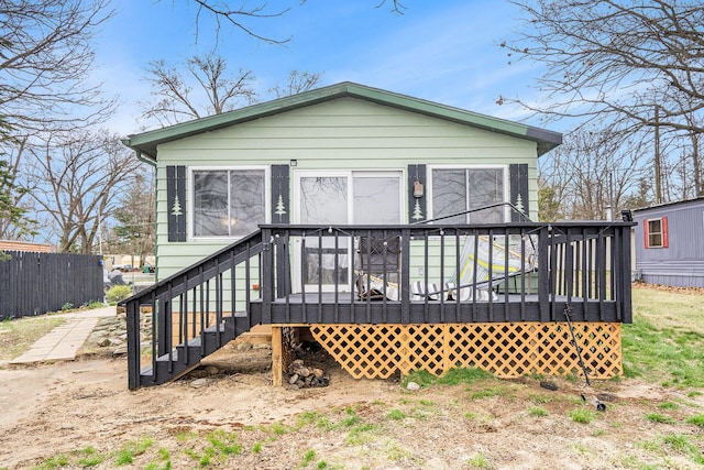 rear view of property with fence and a deck