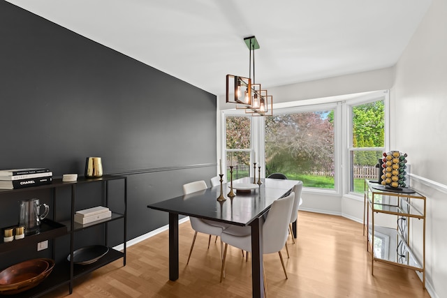 dining space with baseboards and wood finished floors