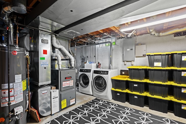 clothes washing area featuring heating unit, separate washer and dryer, laundry area, electric panel, and water heater