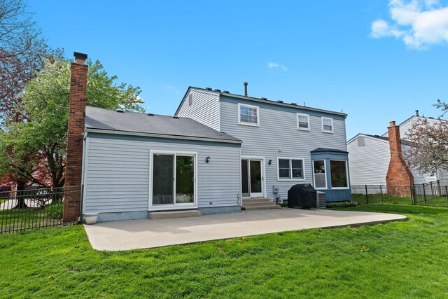 rear view of property with a yard, entry steps, fence, and a patio area