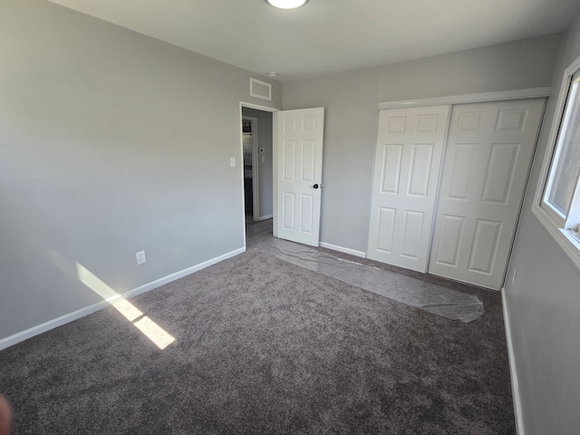 unfurnished bedroom featuring carpet floors, baseboards, visible vents, and a closet