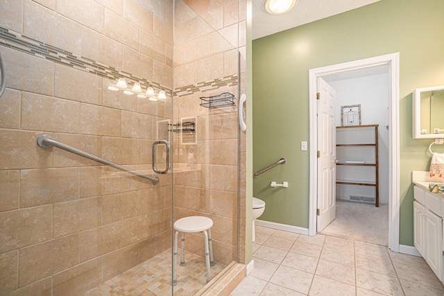 bathroom featuring baseboards, toilet, vanity, and a stall shower
