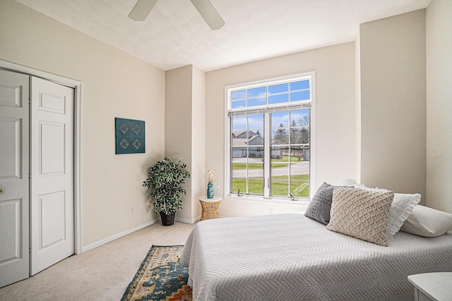 bedroom with ceiling fan, carpet floors, multiple windows, and baseboards