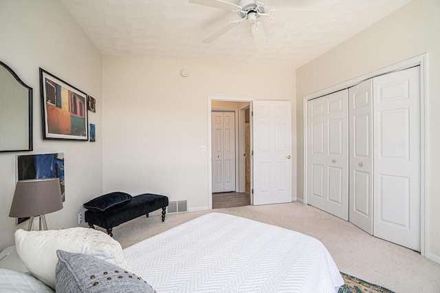 bedroom featuring a closet, ceiling fan, light carpet, baseboards, and visible vents