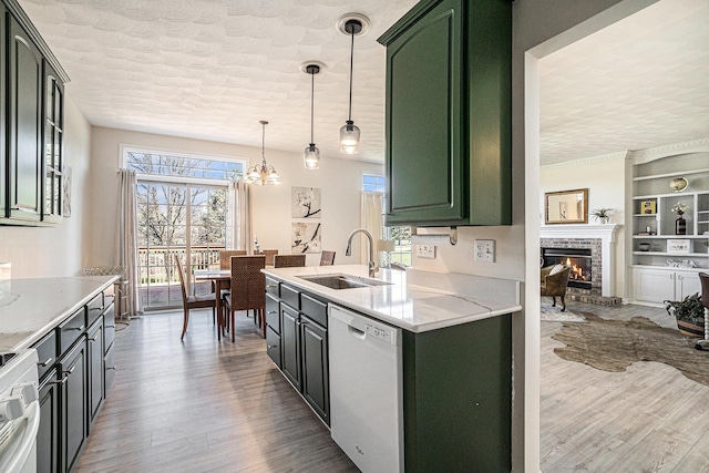 kitchen featuring a sink, a textured ceiling, white dishwasher, green cabinets, and range