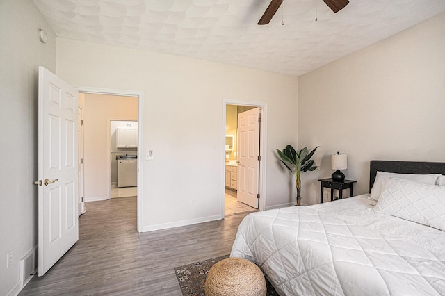 bedroom featuring ensuite bath, baseboards, a ceiling fan, and wood finished floors