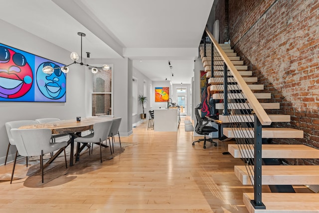 interior space featuring baseboards, hardwood / wood-style flooring, and brick wall