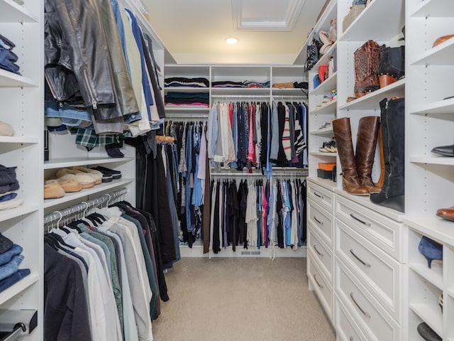 walk in closet featuring attic access and light colored carpet