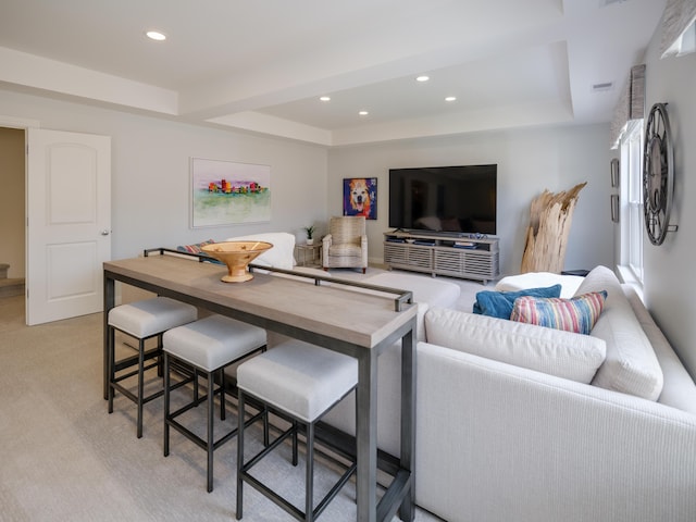 living area featuring light carpet, a tray ceiling, and recessed lighting