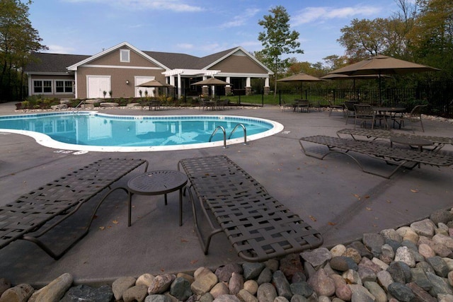 pool featuring fence and a patio