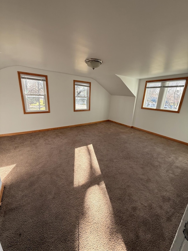 bonus room with lofted ceiling, carpet floors, and baseboards