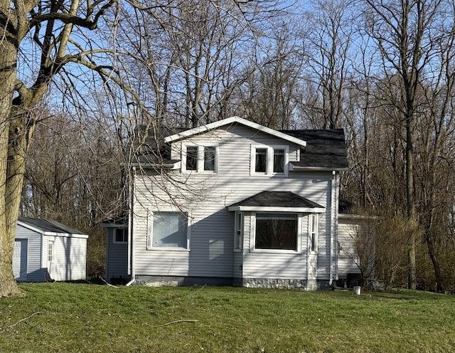 back of property with a lawn, an outbuilding, and a shed
