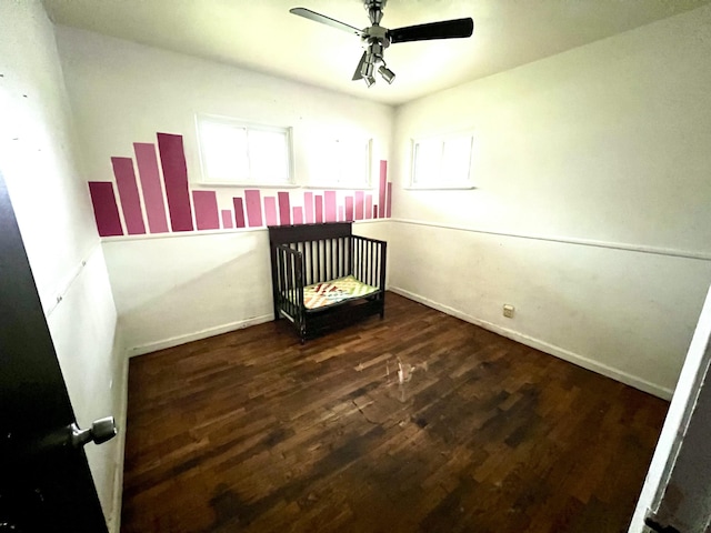 unfurnished bedroom featuring wood finished floors, a ceiling fan, and baseboards