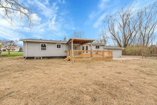 rear view of property featuring a wooden deck and a yard