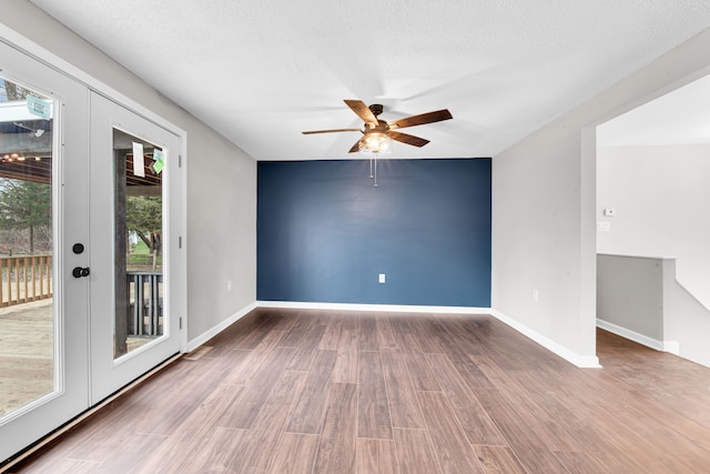 unfurnished room with wood finished floors, a textured ceiling, baseboards, and ceiling fan