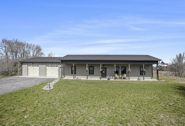 view of front of property featuring a garage, driveway, a front yard, and metal roof