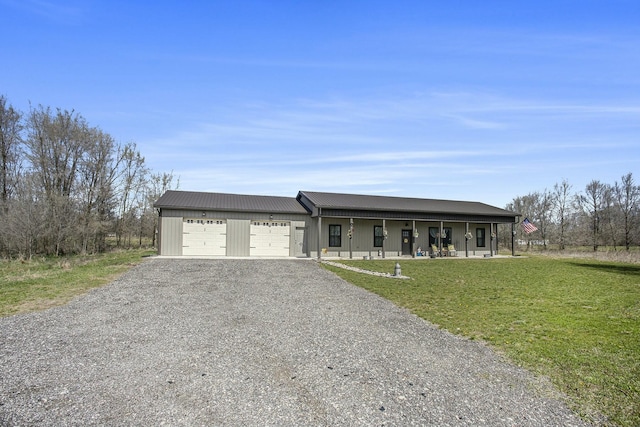 ranch-style house featuring an attached garage, driveway, a porch, a front yard, and metal roof