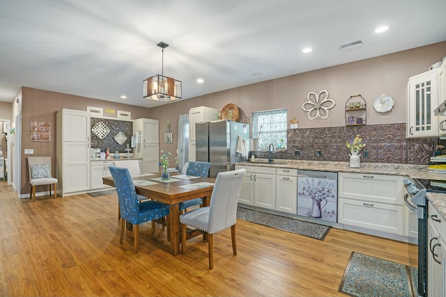 dining space with light wood finished floors, visible vents, an inviting chandelier, and recessed lighting