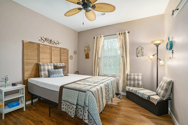 bedroom with wood finished floors, visible vents, a ceiling fan, and baseboards