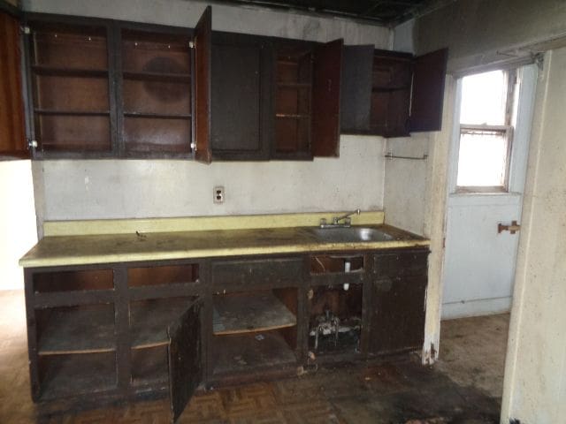 kitchen featuring dark brown cabinets and a sink