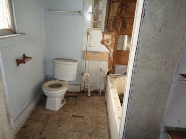 full bathroom featuring a bath and toilet